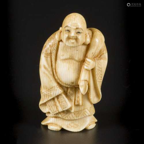 An ivory okimono of a laughing/ happy Buddha as traveller, J...