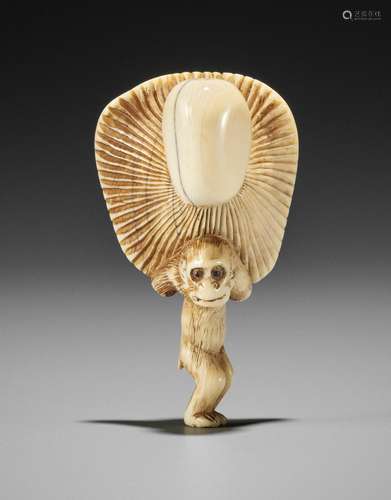 TOMOKAZU: AN IVORY NETSUKE OF A SMALL MONKEY CARRYING A LARG...