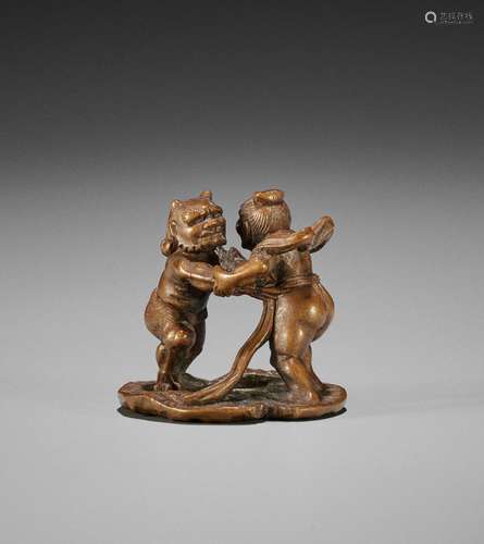 A SMALL WOOD NETSUKE OF A NIO AND ONI WRESTLING ON A LOTUS L...