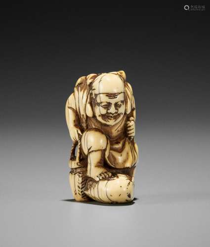 MIZAN: AN IVORY NETSUKE OF EBISU STEPPING ON A FISH