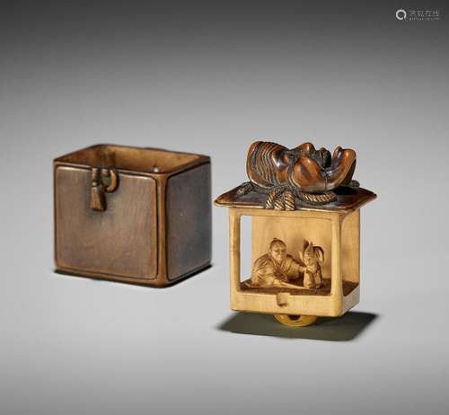 AN UNUSUAL WOOD NETSUKE OF A BUNRAKU WITHIN A MASK STORAGE B...