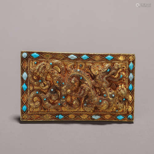 A golden turquoise-inlaid ornament