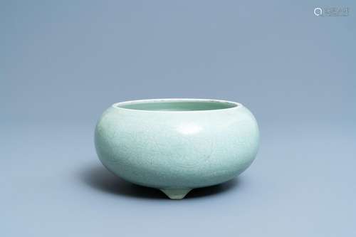 A CHINESE CELADON-GLAZED TRIPOD CENSER WITH INCISED UNDERGLA...