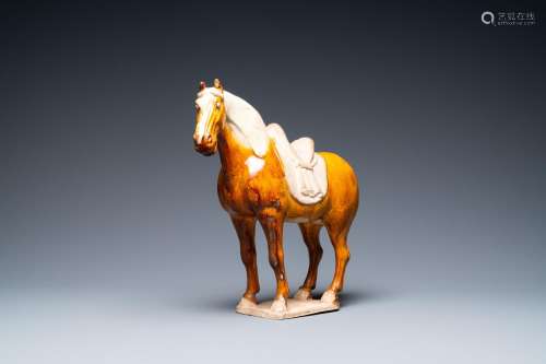 A CHINESE AMBER- AND CREAM-GLAZED POTTERY MODEL OF A HORSE, ...