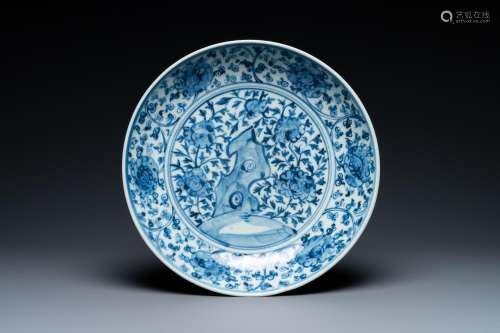 A CHINESE BLUE AND WHITE DISH WITH ROCKWORK SURROUNDED BY FL...