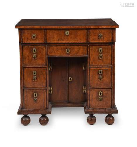 A QUEEN ANNE WALNUT AND FEATHERBANDED KNEEHOLE DESK, CIRCA 1...