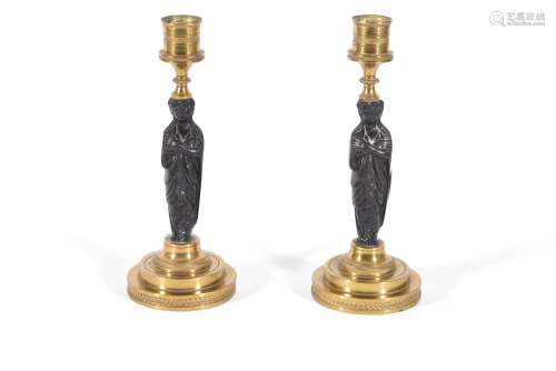 A PAIR OF FRENCH BRONZE AND ORMOLU CANDLESTICKS, PROBABLY TH...