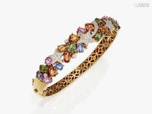 A bangle with star motifs and multi-coloured sapphires and b...