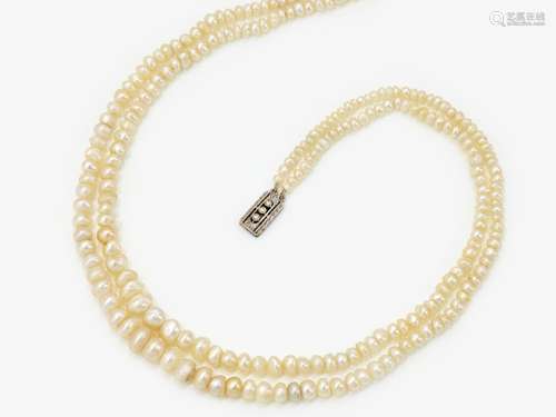 A 2-strand natural pearl necklace with a decorative clasp