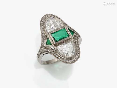 An exquisite Art Deco ring studded with diamonds and emerald...