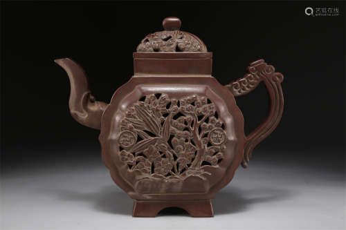 A Purple Clay Teapot with Flowers Design.