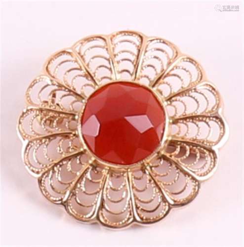A 14 krt 585/1000 gold brooch, set with faceted carnelian.