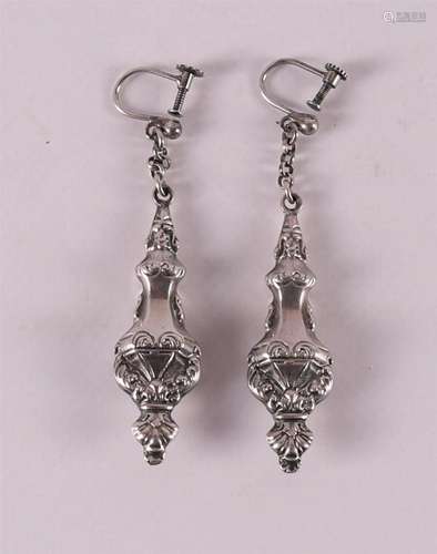 A pair of silver earrings with screw closure.