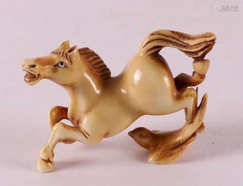 A carved ivory jumping horse with bird, China, circa 1900.