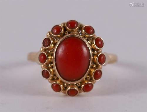 A 14 kt gold entourage ring with cabochon cut red corals.
