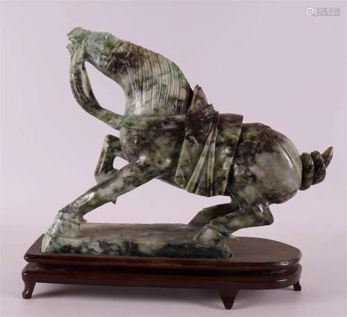 A basalt jade sculpture of a horse on a loose wooden base, C...