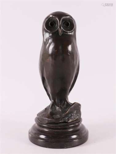 A brown patinated bronze owl on a black marble base