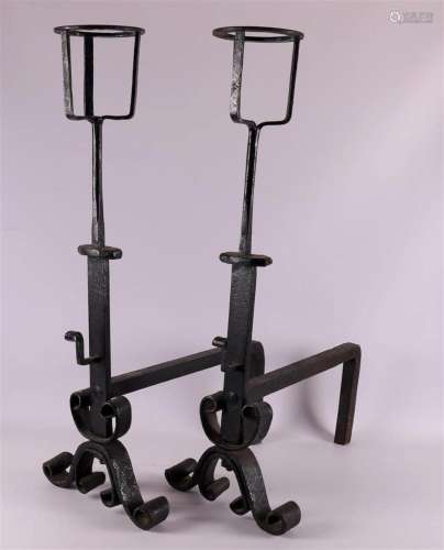 A pair of wrought iron andirons with candle holder, 18th C.
