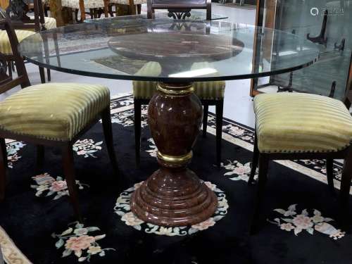 A round dining room table with clear glass top on marble bas...