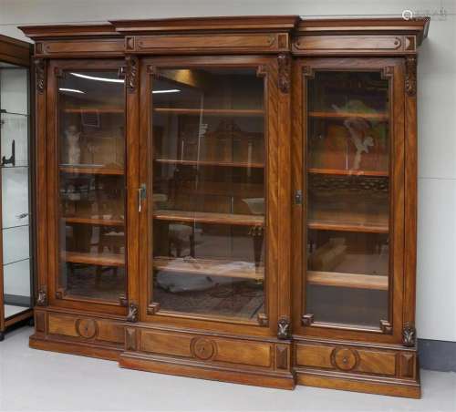 A walnut breakfront bookcase with glazed doors, circa 1900.