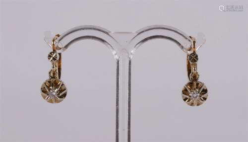 A pair of 18 kt gold stud earrings with 2 diamonds.