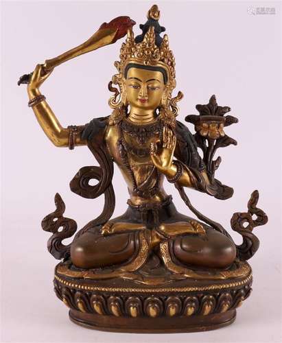 A brown patinated bronze and gilt Manjushri Bodhisattva on l...