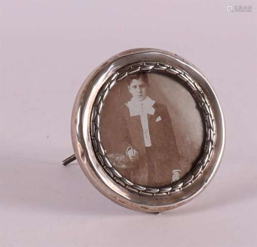 A round metal picture frame with a silver rim, early 1900s.