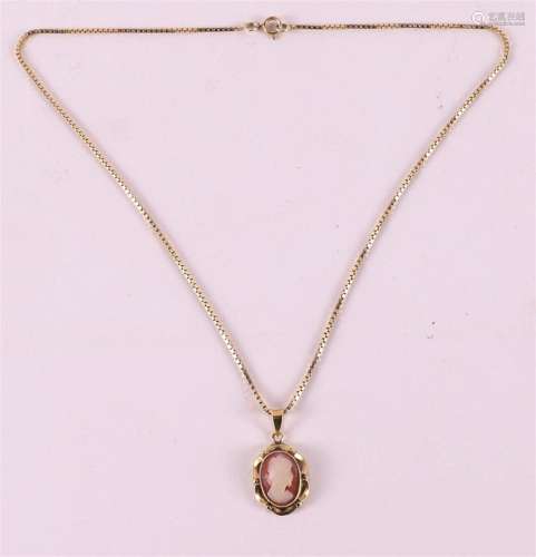 A 14 kt yellow gold cameo pendant on a gold necklace.