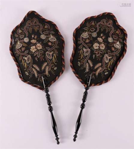 A set of black fabric fans with floral decor on ebonised han...