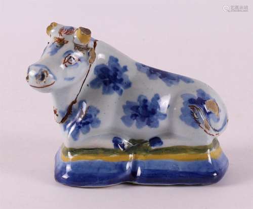 A Dutch Delft blue/white earthenware reclining cow, 18th C.