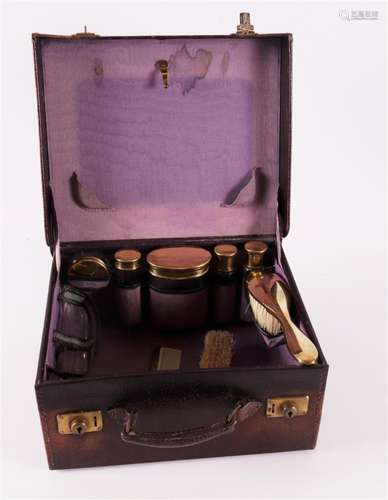 A brown leather toilet case containing glass bottles, Englan...