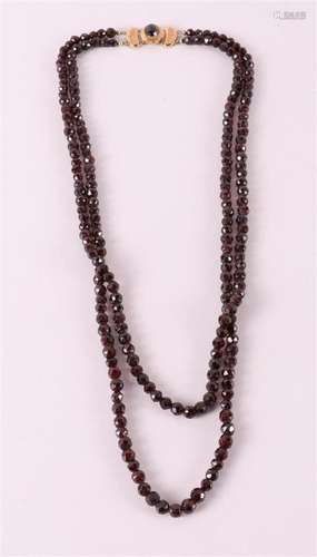 A two-row necklace with faceted glass garnets on a 14 kt gol...