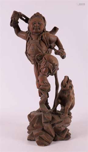 A tropical wooden man with a dog, China, 20th century.