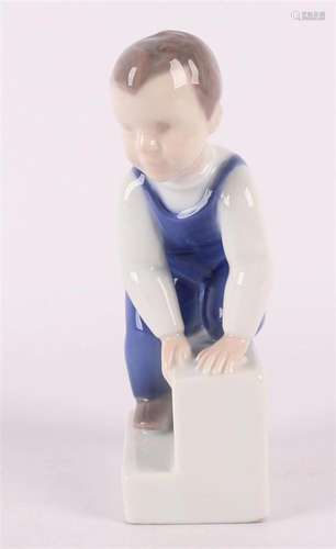 A porcelain boy on a staircase, marked: Royal Copenhagen.