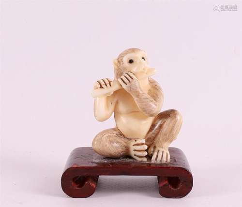 An ivory okimono of a monkey playing flute, Japan, ca. 1920.