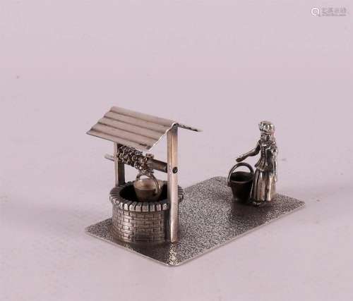 A 2nd grade silver miniature of a lady with a bucket at a we...