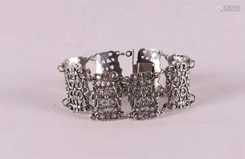 A 2nd grade silver link bracelet with floral decoration.