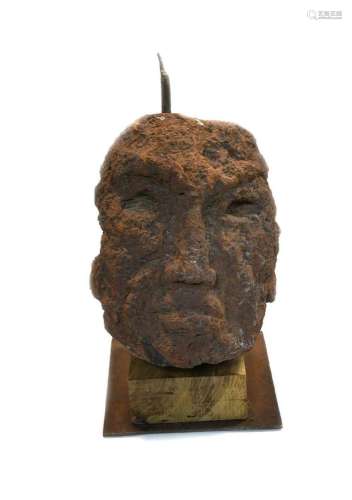 A carved tufa primitive head of a man, Saint-Pons, Ardèche R...