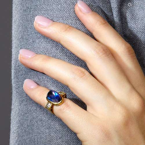 An imitation blue stone, diamond and 18K yellow gold ring. G...