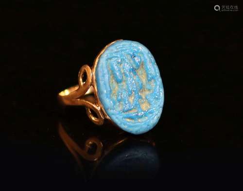 An antique gold and oval turquoise glazed intaglio set ring