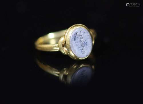 An antique gold and oval chalcedony set ring, carved with th...