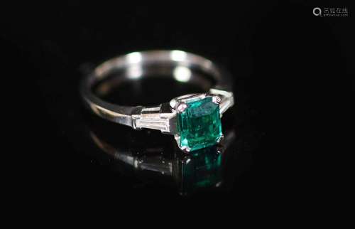 A platinum and single stone emerald ring with trapeze cut di...