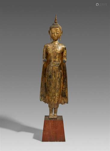A large Ayutthaya lacquered and gilt bronze figure of a stan...