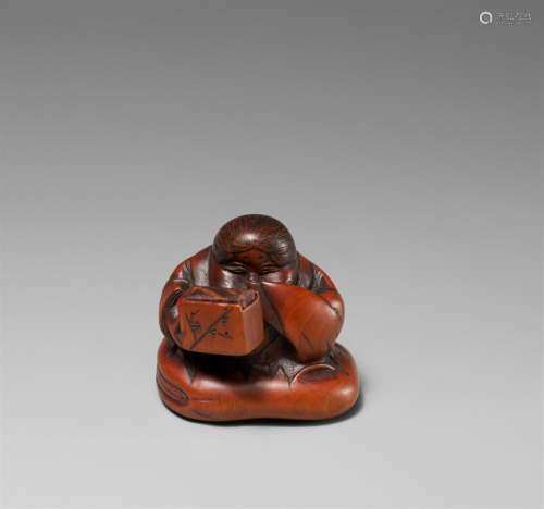 A boxwood netsuke of a Okame with a box. 19th century