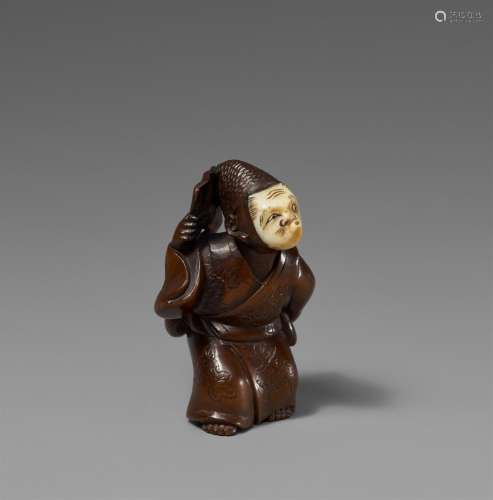 A wood and ivory netsuke of a dancer. Mid-19th century