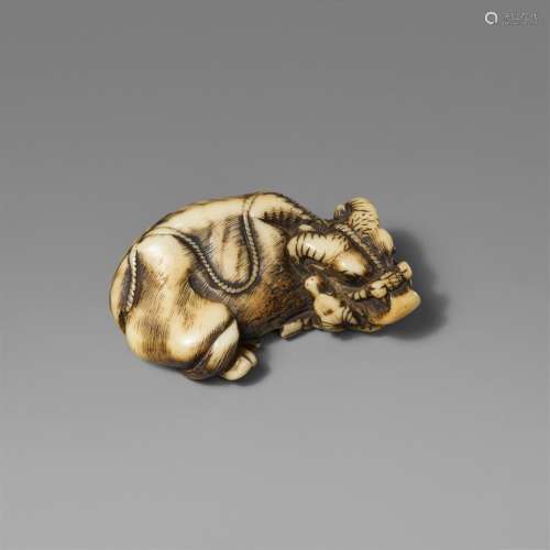 A stag antler netsuke of a recumbent ox with calf. Early 19t...