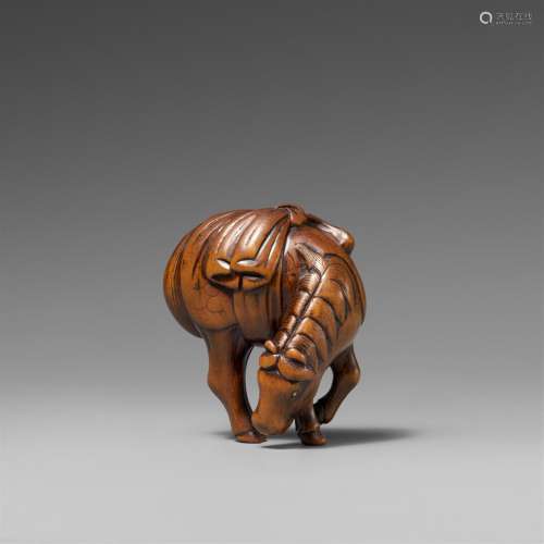 A boxwood netsuke of a grazing horse. Early 19th century