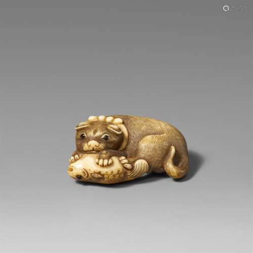 An ivory netsuke of a dog and fugu. First half 19th century