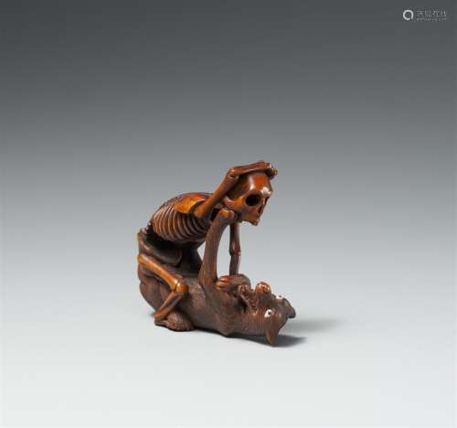 A Hida school boxwood netsuke of a skeleton and a wolf, in t...