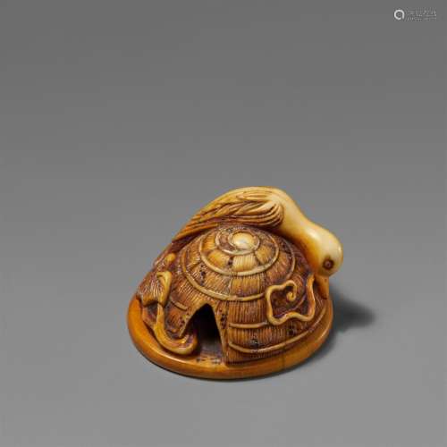 A stained ivory netsuke of a bird on a sedge hat. 19th centu...